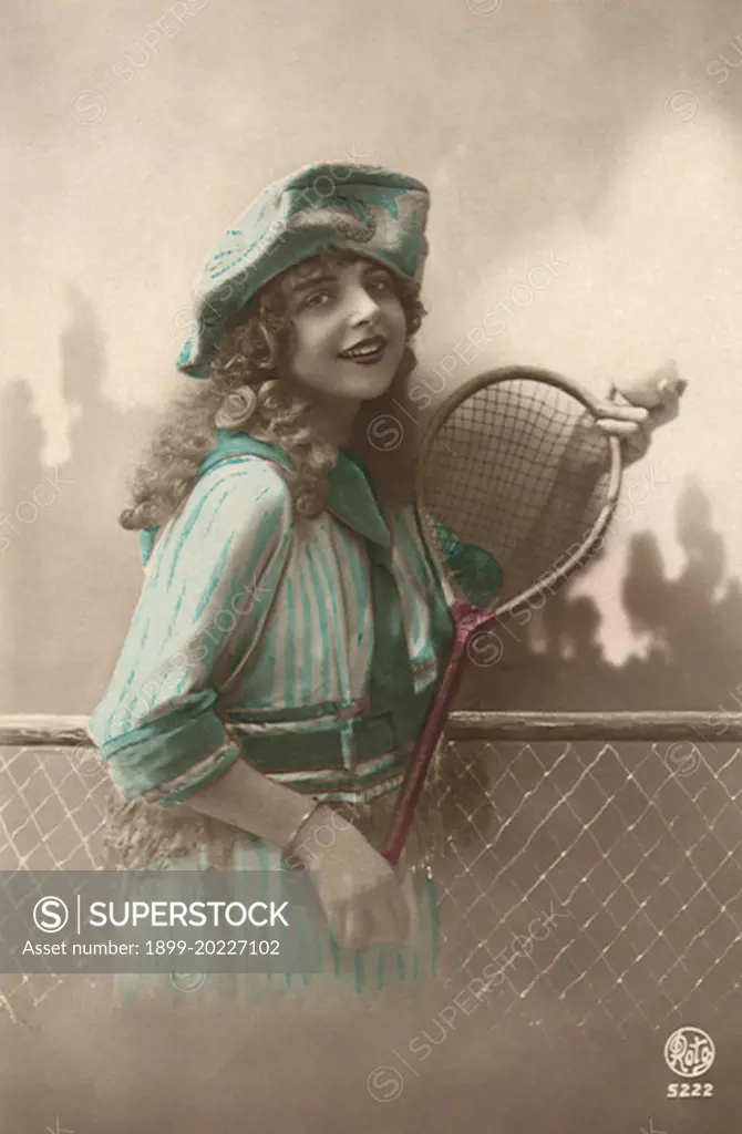 Woman in blue dress with Tennis Racquet and ball. 