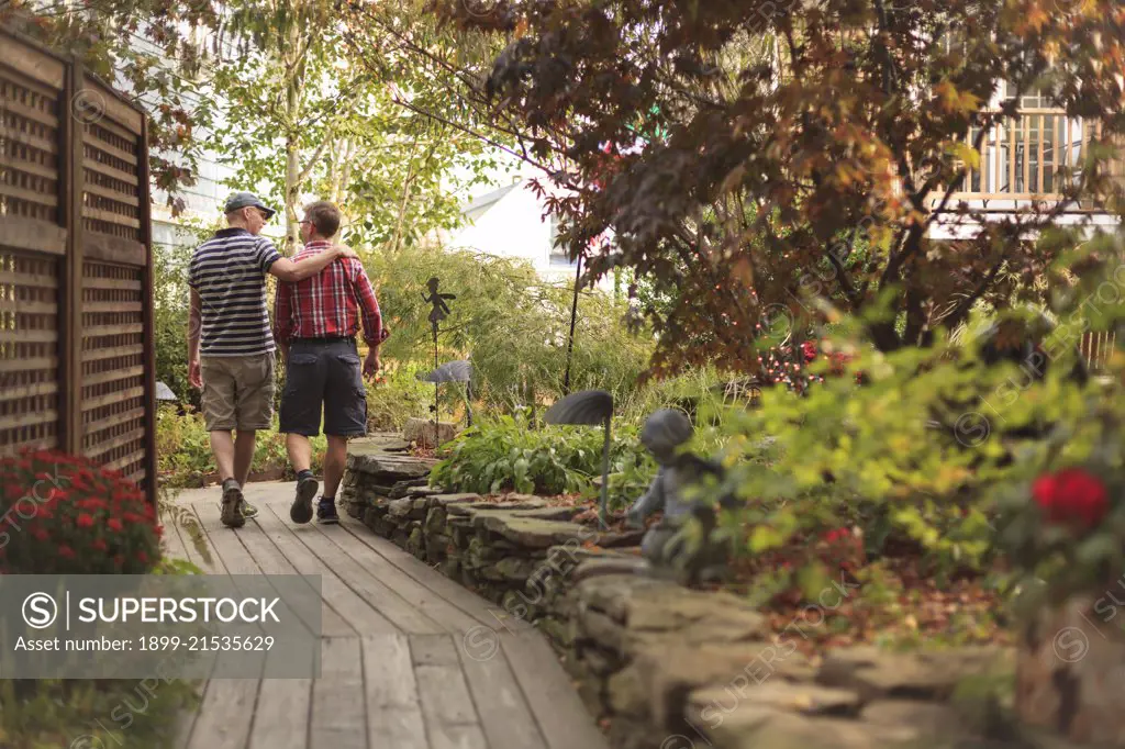 Gay Couple (age 40s) walking through a garden. 