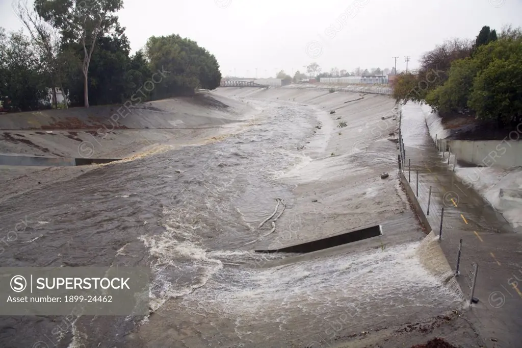 Storm Drainage System. Rain water empties from Storm Pipes into Ballona Creek, a nine-mile waterway that drains the Los Angeles basin. Urban runoff carries an assortment of trash and debris from catch basins where a network of pipes and open channels create a pathway to the Ocean at Santa Monica Bay. Ballona Creek is designed to discharge to Santa Monica Bay approximately 71,400 cubic feet per second from a 50-year frequency storm event. Culver City, Los Angeles, California, USA