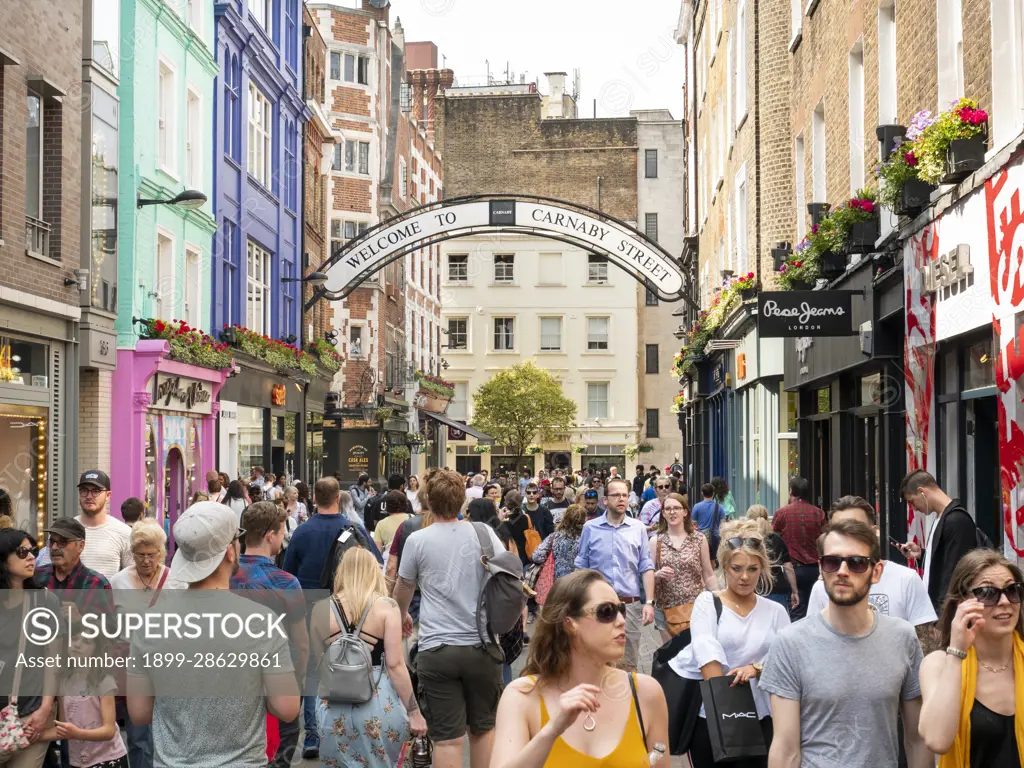 People walking down crowded Carnaby Street in the West End of London, UK