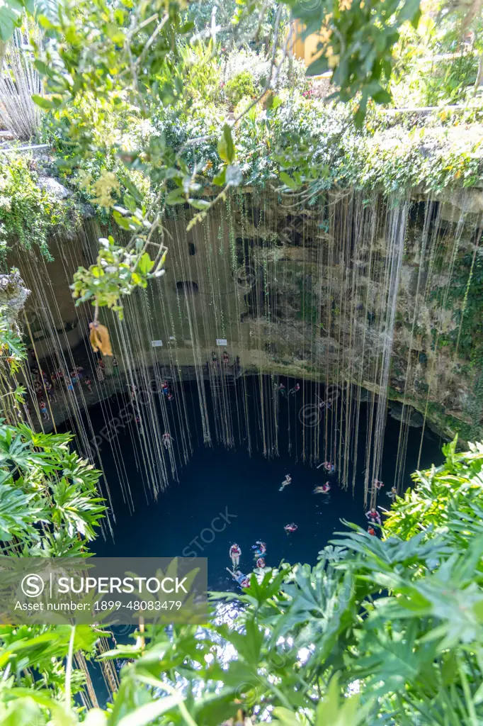 People swimming in limestone sinkhole pool, Cenote Ik kil, Piste, Yucatan, Mexico.