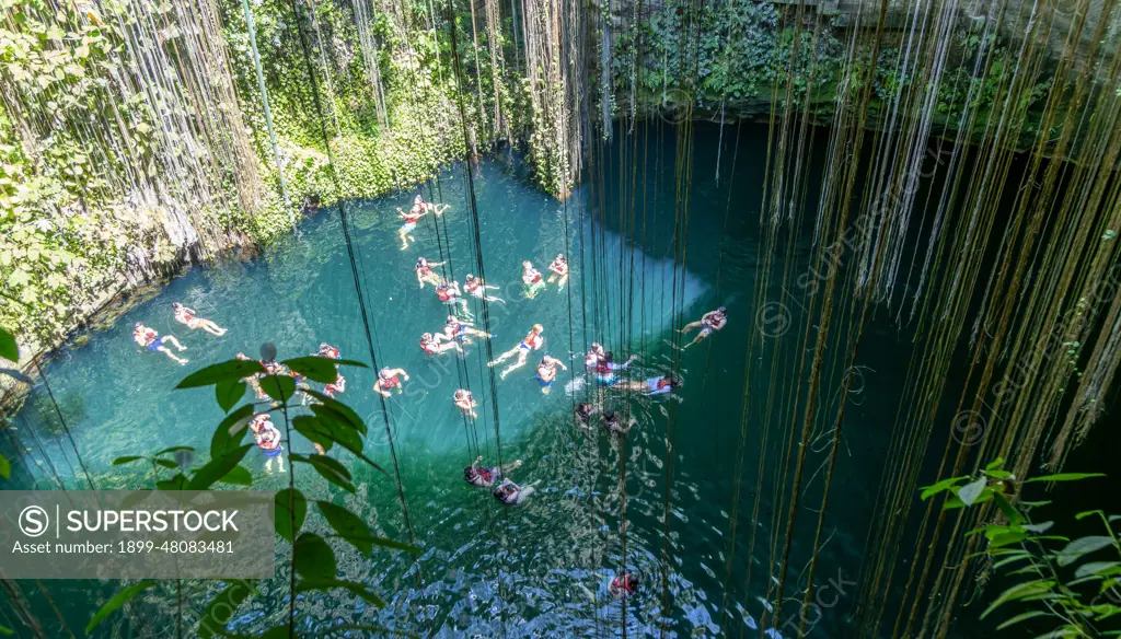 People swimming in limestone sinkhole pool, Cenote Ik kil, Piste, Yucatan, Mexico.