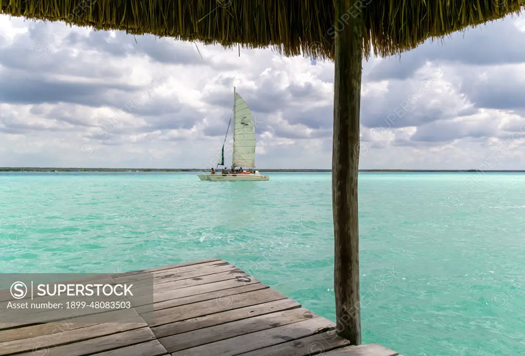 Sailing boat on clear turquoise water of Lake Bacalar, Bacalar, Quintana Roo, Yucatan Peninsula, Mexico.