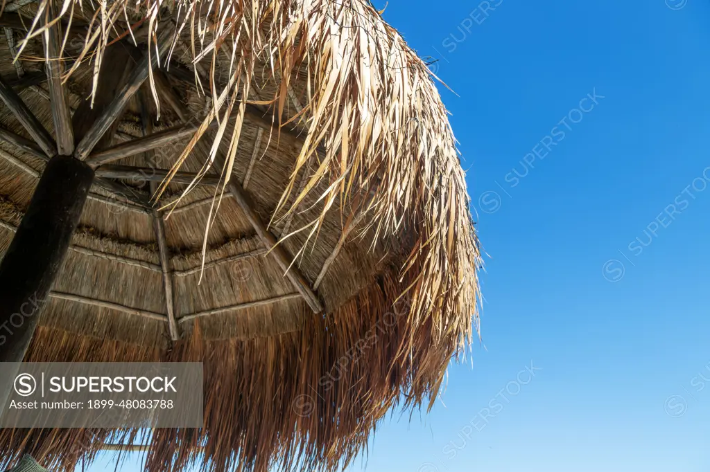 Thatched palapa shelter buildings with blue sky, Gulf of Mexico coast, Celestun, Yucatan, Mexico.