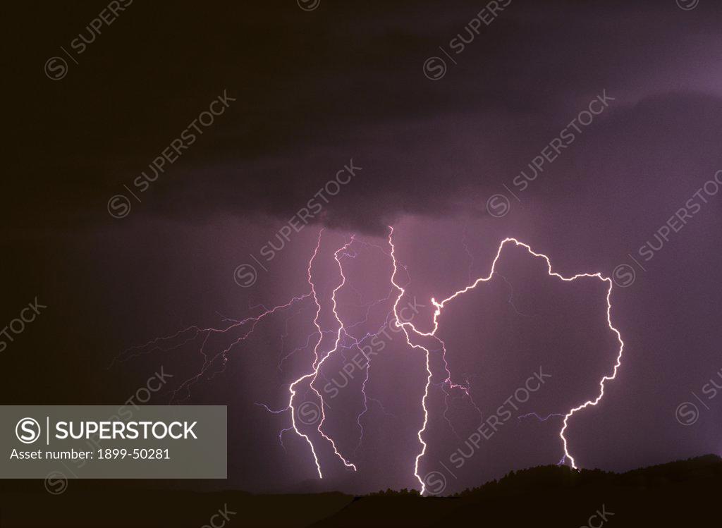Cloud-to-ground lightning discharges, the downward stepped leader of one  discharge nearly returning to the cloud before turning to make its final  descent to the ground. Magdalena Mountains, New Mexico, USA. - SuperStock