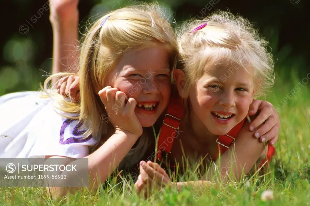 Two Sisters Outdoors Hugging.