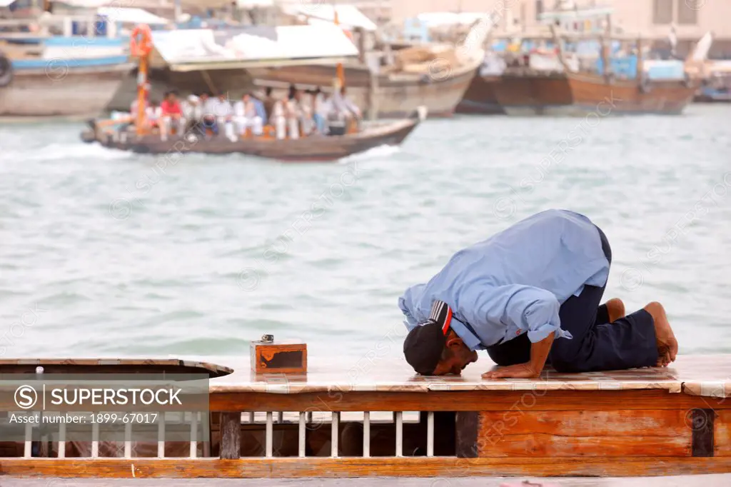 Praying muslim in Dubai harbour