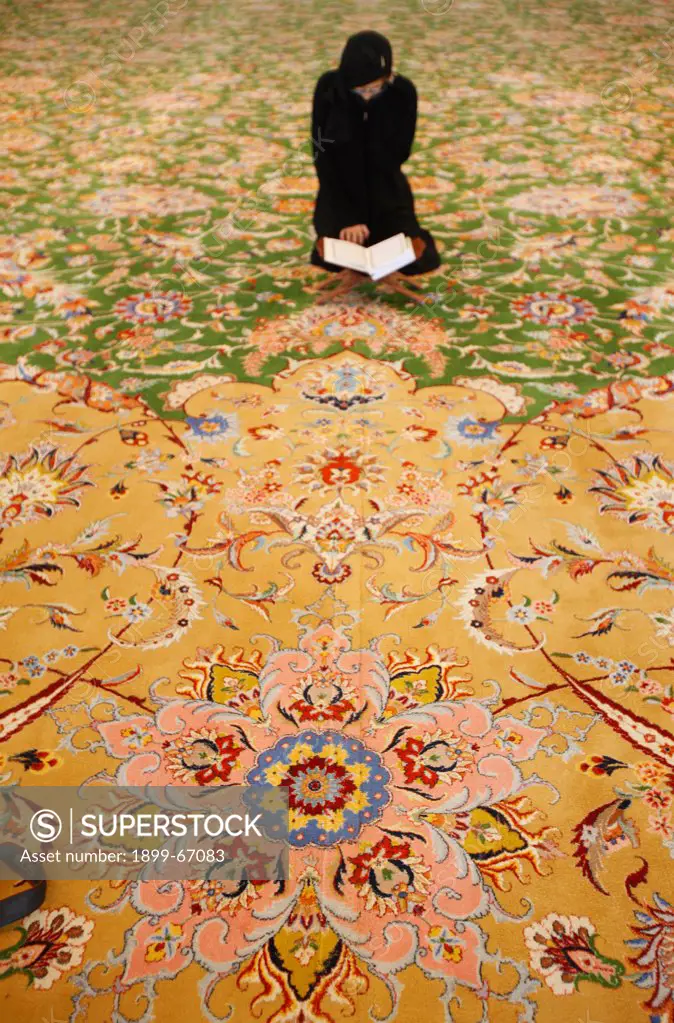 Sheikh Zayed Grand Mosque. Muslim woman reading the koran.