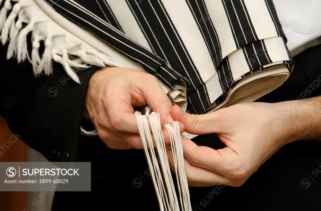 Jew holding taleth tsitsit while praying