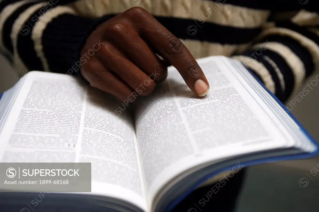 African man reading the bible in a church.