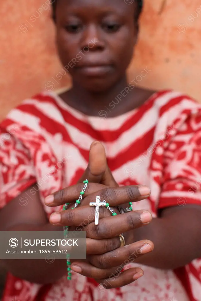 African woman praying the rosary.