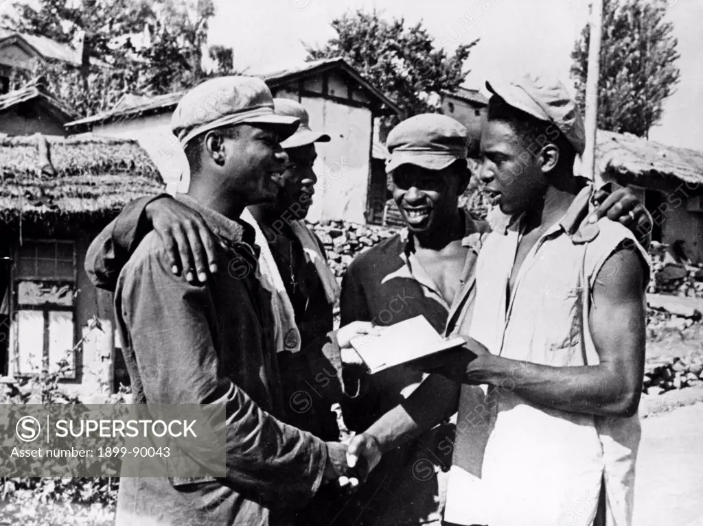 Korean War. African American prisoners in a North Korean POW camp exchanging addresses after the news of the signing of the armistice. August 1953.