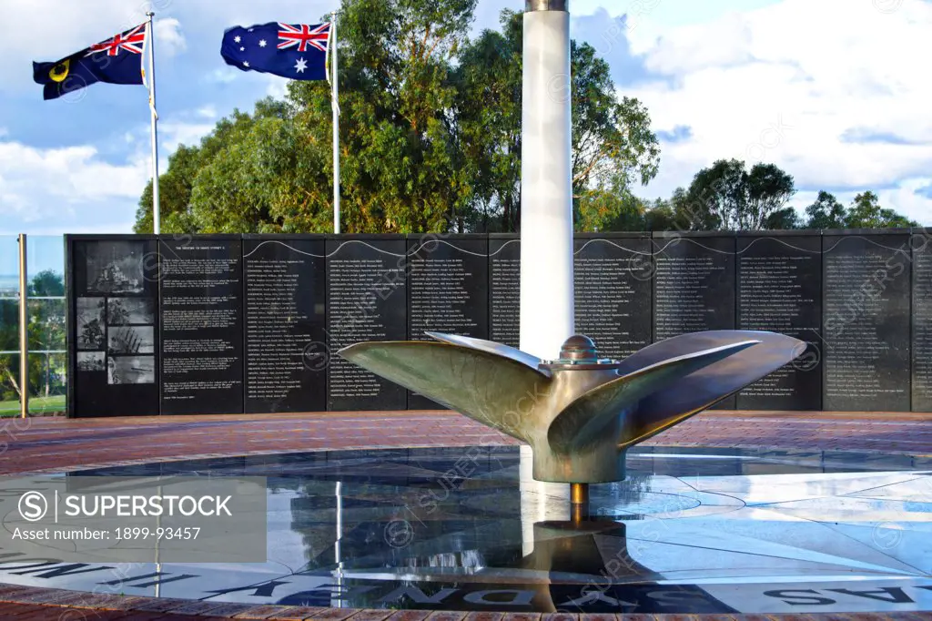 The HMAS Sydney Memorial honours the 645 crew members who lost their lives in a sea battle in 1941, in the foreground is a ship's propeller, centrepiece of the podium below the Dome of Souls, and beyond is the black granite Wall of Remembrance inscribed with names of the lost men, and historic photographs of the warship, Geraldton, Mid West region, Western Australia,6/13/2011