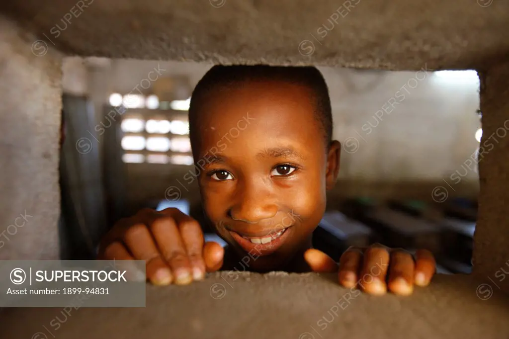 African boy looking through an opening, Lome, Togo.,02/11/2009