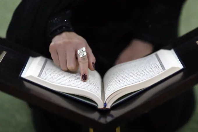 Muslim woman reading the noble Quran in mosque.  Dubai. United Arab Emirates.