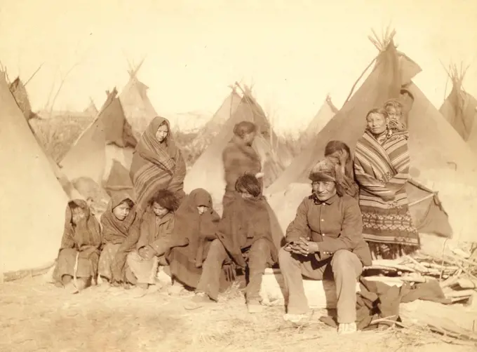 Group of eleven Miniconjou (children and adults) in a tipi camp, probably on or near Pine Ridge Reservation. 1891.