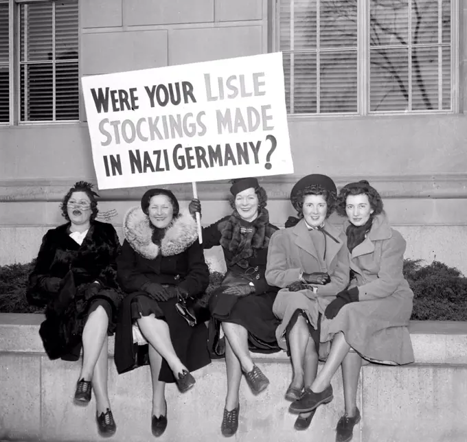 Women protesting for silk hose, holding picket sign - anti-nazi sign  circa 1938.