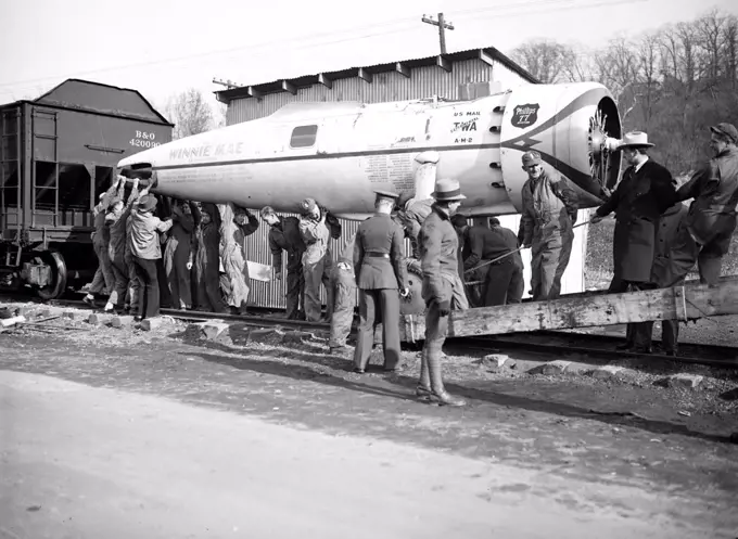 The Winnie Mae, famous globe circling plane with carried the late Wiley Post around the world solo is unloaded at Bolling field, Washington, under the direction of Smithsonian Institution circa 12/2/1935.