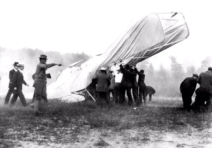 1908 - Bystanders help extricate the mortally wounded US Army (USA) Lieutenant (LT) Thomas Selfridge from the wreck of the Wright Brothers Flyer after its crash at Fort Myer, Virginia (VA). At right, several men attend the injuries of Orville Wright, who lies on the ground at their feet. 