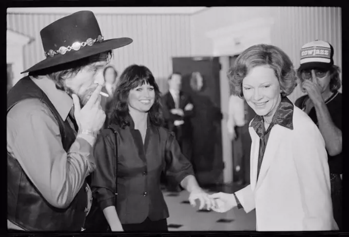 April 23, 1980 - First Lady Rosalynn Carter with Waylon Jennings, smoking a cigarette, and Jesse Colter at a reception preceding a concert to benefit the Carter-Mondale campaign.