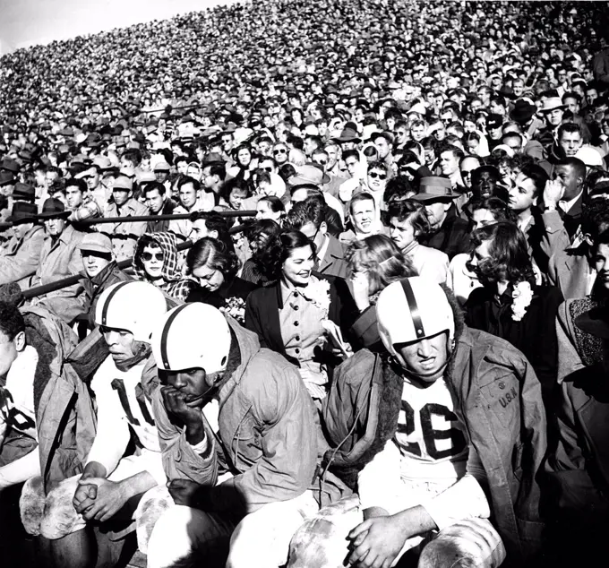 May 1950 - View of Football Crowd and Players on Bench During Game . 