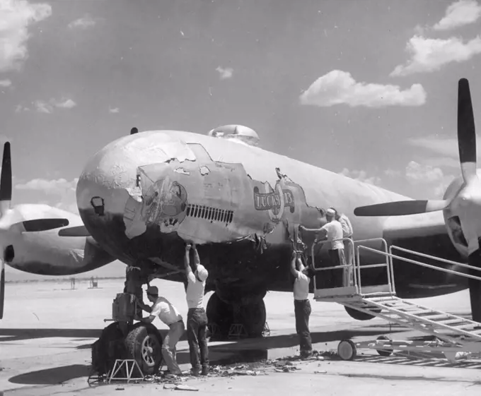 A reconditioning crew peel off the "cocoon" encasing a B-29 bomber stored at an airfield somewhere in the southwestern United States, in preparation for the aircraft's return to duty in the Korean War, Southwestern United States, 1950. (Photo by United States Information Agency/GG Vintage Images)