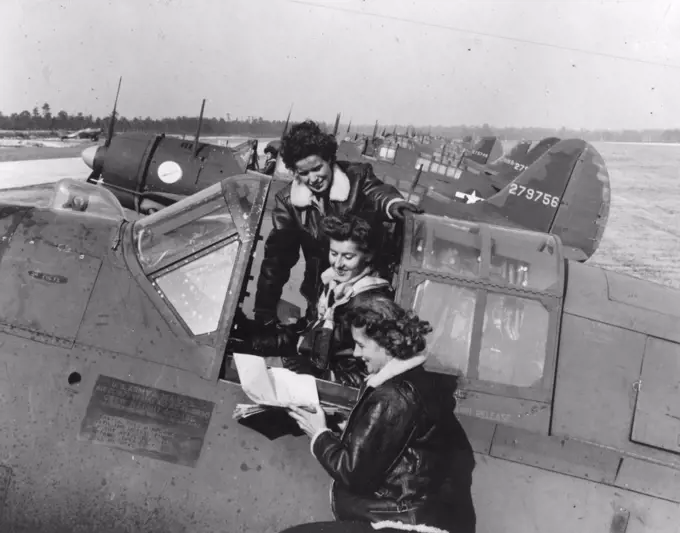 WASPs around a Curtiss A-25A making last minute check-ups before taking off. Army Air Field Camp Davis, NC. Circa 1944. 