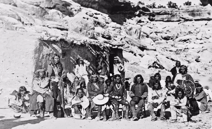 Paiute Indian group posed in front of adobe house ca. 1909.