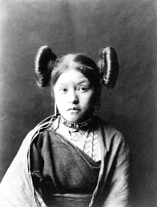 Gobuguoy, Walpi girl, hair tied in swirls on sides of head, cotton shawl around shoulders ca. 1900. 