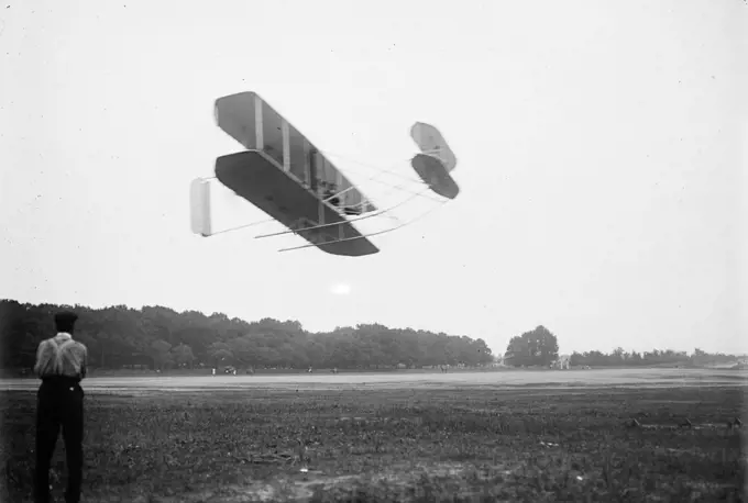 Orville Wright and aeroplane, in flight over field 7 1 1909. 