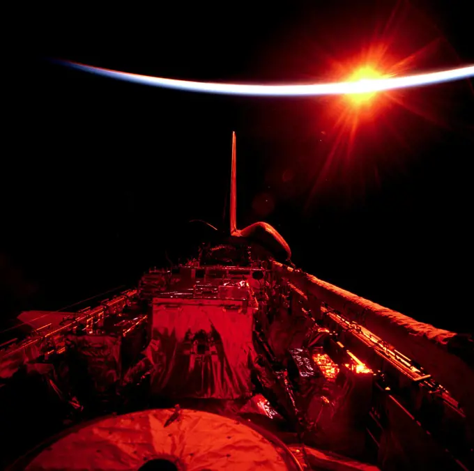 (21 Feb. 1997) --- This scene of the sun setting on the Space Shuttle Discovery's almost empty cargo bay symbolizes the successful conclusion of the mission, as the seven astronauts inside the crew cabin approach one of the final mission chores -- that of closing the cargo bay doors. The astronauts earlier completed five days of Extravehicular Activities (EVA) designed to service the giant Hubble Space Telescope (HST), now noticeably missing in the bay. At bottom center is part of the top of the exit airlock, making its first flight.. 