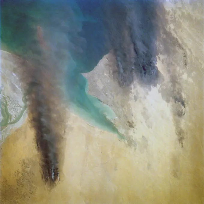 Oil wells to the north of the Bay of Kuwait and just south of Kuwait City, on the south shore, can be seen burning out of control. Compared with pictures of the same area shot during STS-37 (April 1991), this frame shows a complete shift of winds, with much of the smoke blowing eastward over the Gulf. The STS-37 scenes showed lengthy southward-blowing sheets of smoke toward Saudi Arabia. In this view, the Gulf island Faylakah Awhah is barely visible through the smoke.. 