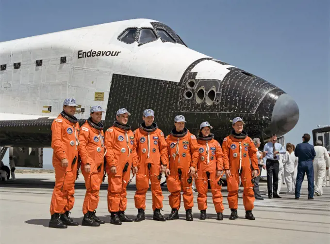(16 May 1992) --- The seven crewmembers of STS-49 pose near Endeavour for a post-flight shot soon after getting their feet on terra firma following nine days in Earth orbit. Left to right are astronauts Richard Hieb, Kevin Chilton, Daniel Brandenstein, Thomas Akers, Pierre Thuot, Kathryn Thornton and Bruce Melnick. Brandenstein was mission commander; Chilton, pilot; and the others, mission specialists.. 
