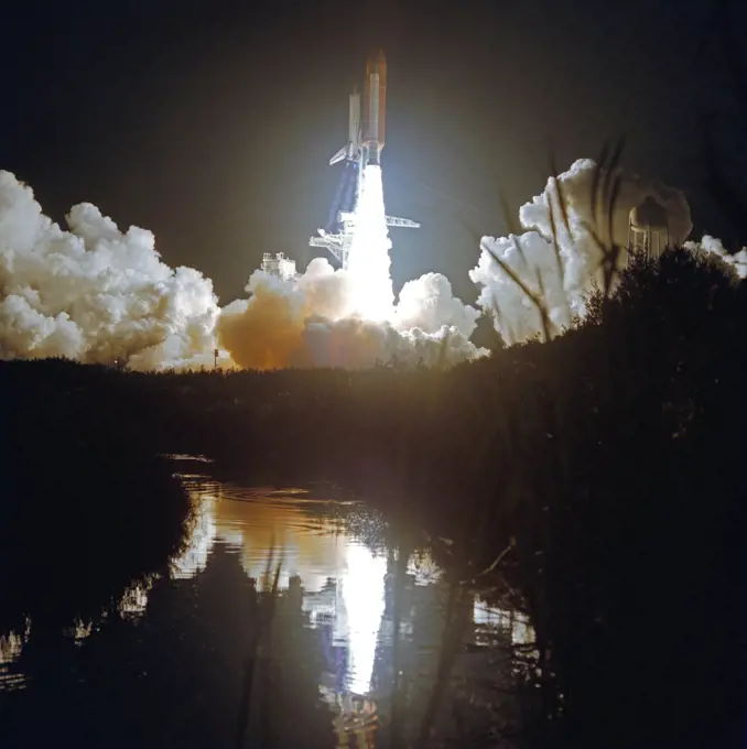 (24 Nov 1991) --- A wide shot of Atlantis' liftoff for STS-44 was recorded by a remote camera.  At 6:44 EST, Nov. 24, 1991, the spacecraft headed toward Earth orbit with a crew of six aboard.  The event is reflected in the KSC marsh waters.  Darkness accentuates the diamond shock effect from the three main engines.. 