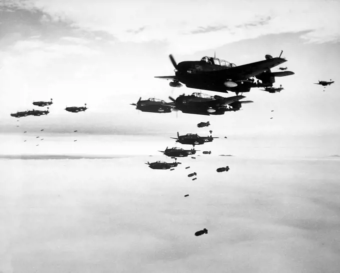 Japan/USA: U.S. Navy Grumman TBM-3 Avengers and Curtiss SB2C Helldivers from the aircraft carrier USS Essex dropping bombs on Hakodate, Japan, in July 1945