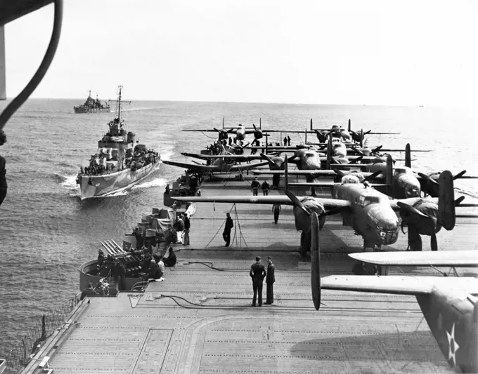 USA/Japan: Some of the B-25 Mitchell Bombers of the Doolittle Raiders crowd the rear deck of the USS Hornet with two escort vessels following close in the background, north Pacific, April 1942