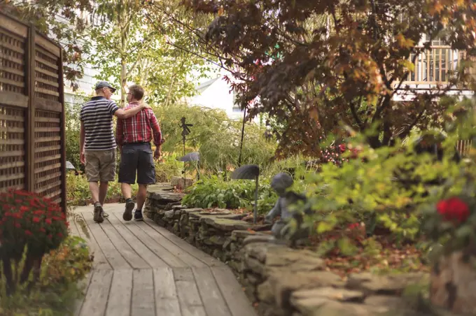 Gay Couple (age 40s) walking through a garden. 