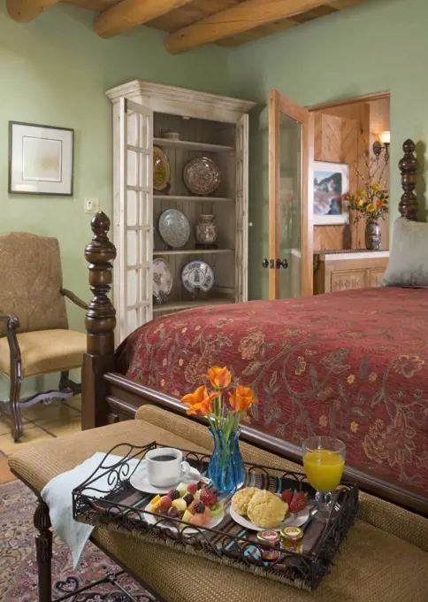 Breakfast tray with vase of flowers at end of mahogany four poster bed, Santa Fe, New Mexico. 