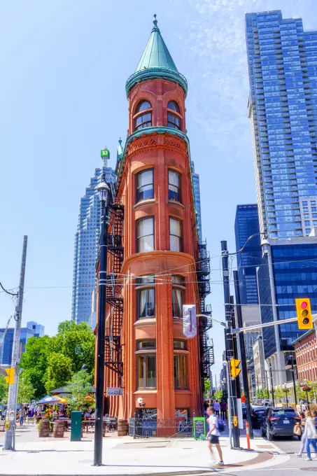 Toronto, Canada, Gooderham building exterior. The heritage landmark structure is located in the old town. Incidental people walk in the front view street scene.