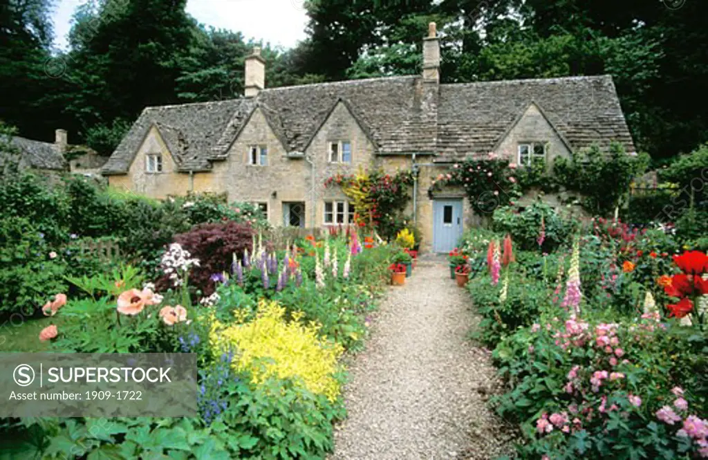 Ancient cottages and traditional english cottage gardens with flowers in summer Bibury Gloucestershire Glos Cotswolds England United Kingdom UK Great Britain GB British Isles Europe