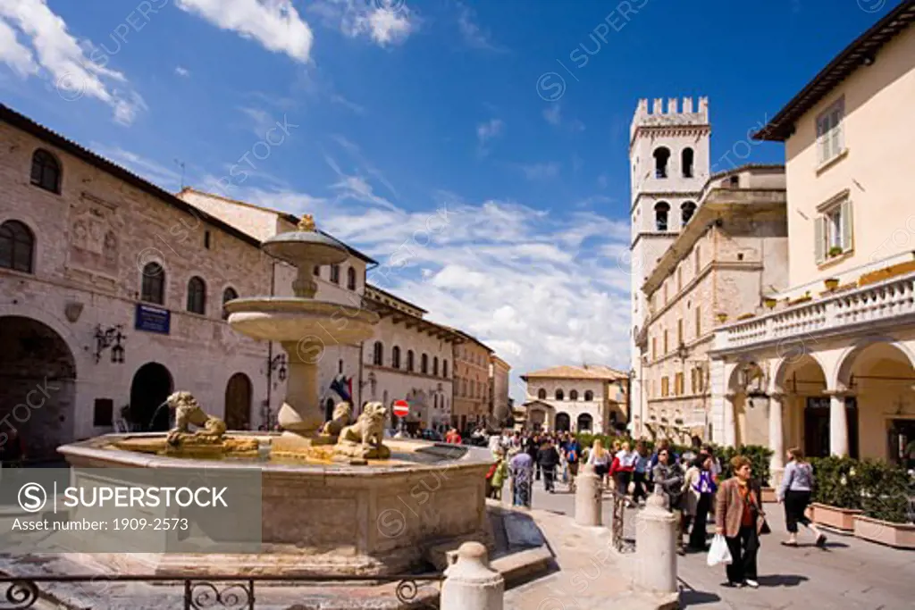 Assisi town centre square with fountain in summer with blue sky sun sunshine sunny white clouds Asissi Assissi Umbria Italy Italia Europe EU