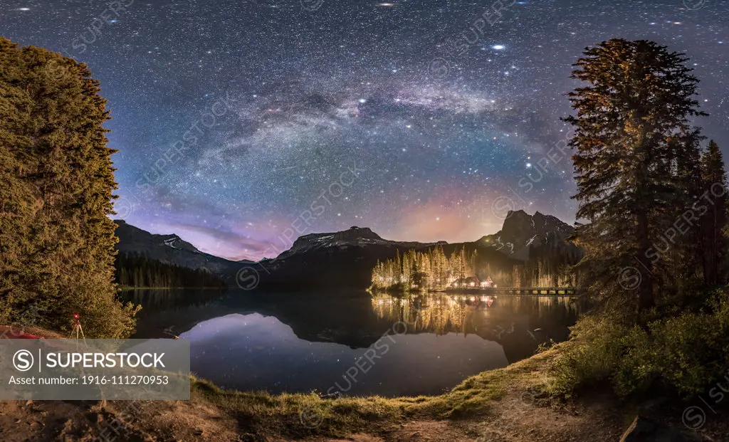 The Milky Way arching over Emerald Lake and Emerald Lake Lodge in Yoho National Park, BC. This was on June 6, 2016 and despite it being about 1:30 am, the sky, especially to the north at left, is still lit by blue twilight from the short solstice night. Unfortunately, the lights from the Lodge, in particular one bright unshielded sodium vapour light, illuminates the foreground and even across the lake. The lights are themselves not overly bright but the long exposures in such images really bri