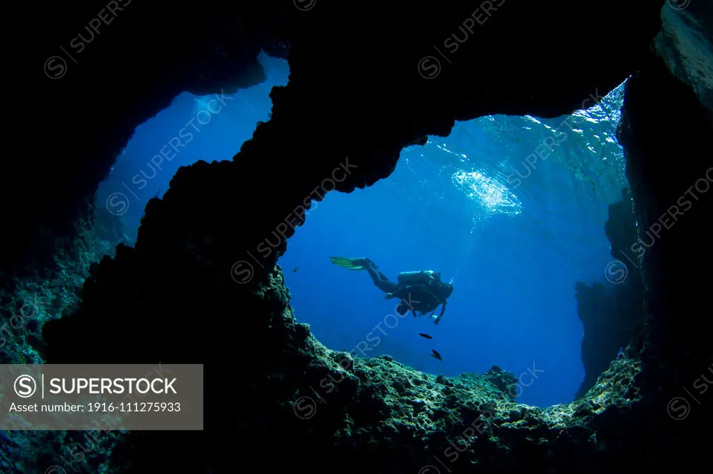 A diver swims past Boo Windows on Boo Island, Raja Ampat, West Papua, Indonesia, Pacific Ocean