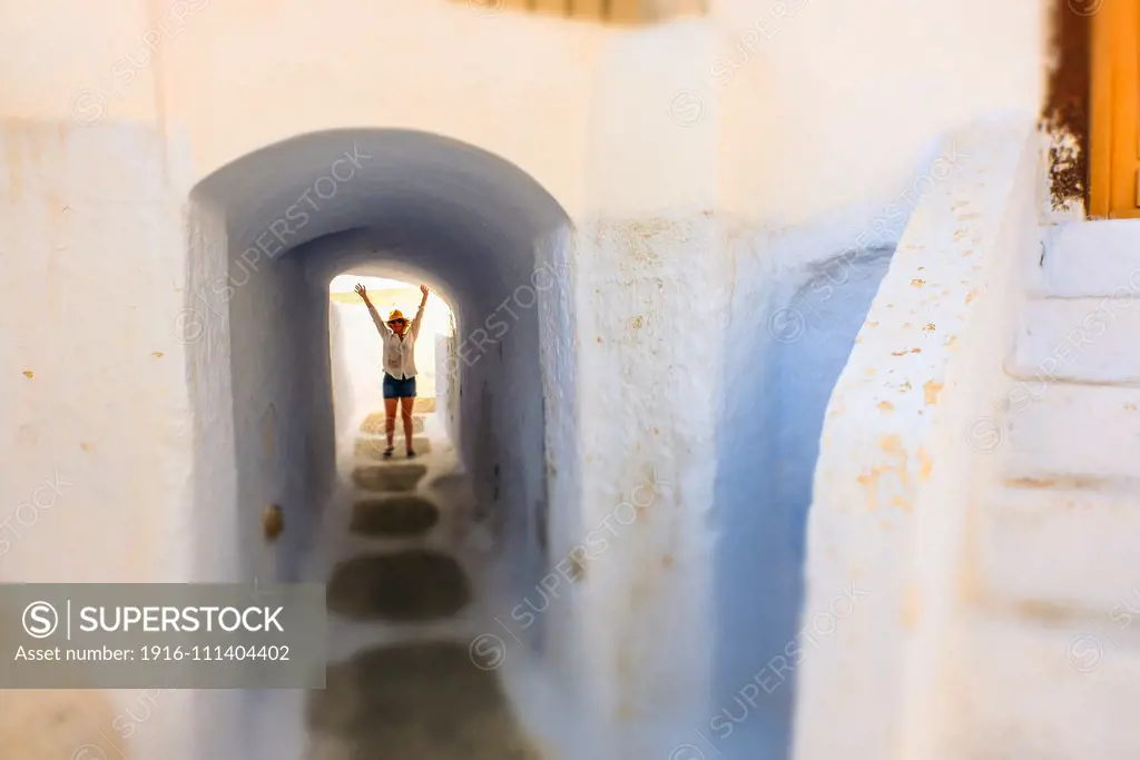 Woman and street view. Pyrgos village. Santorini. Cyclades islands. Greece.