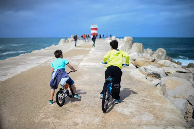 Kids on bike in dock of Nazare, Portugal