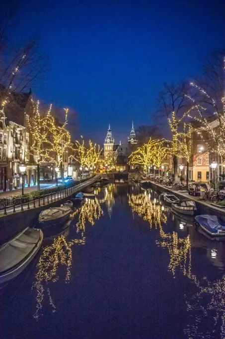 Beautiful lighted trees line the  Amsterdam canal dubbed the "Venice of the North" which leads to Rijksmuseum a Dutch history museum in Amsterdam, Netherlands