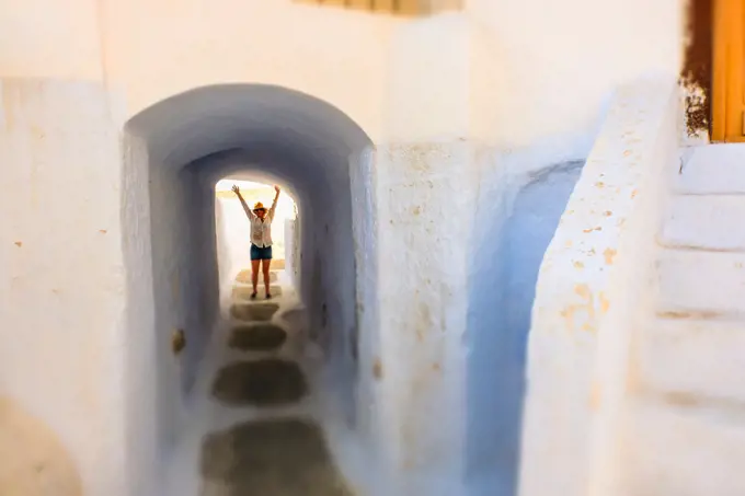 Woman and street view. Pyrgos village. Santorini. Cyclades islands. Greece.