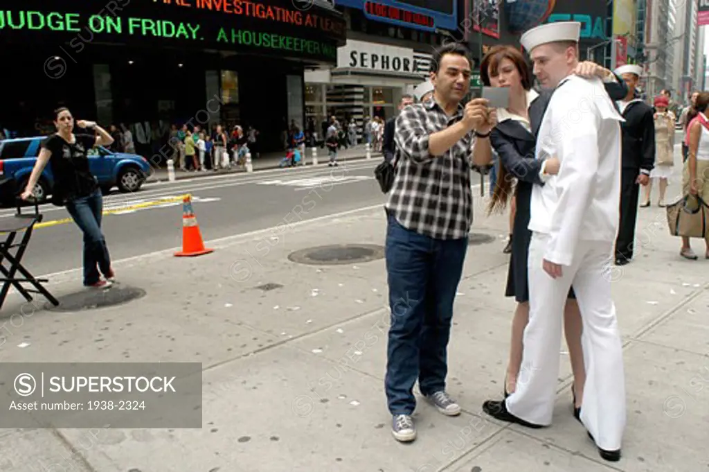 Commercial photo session in Times Square  NYC  recreating the famous picture where a man kisses goodbye a woman   changing the roles  in Manhattan  New York City