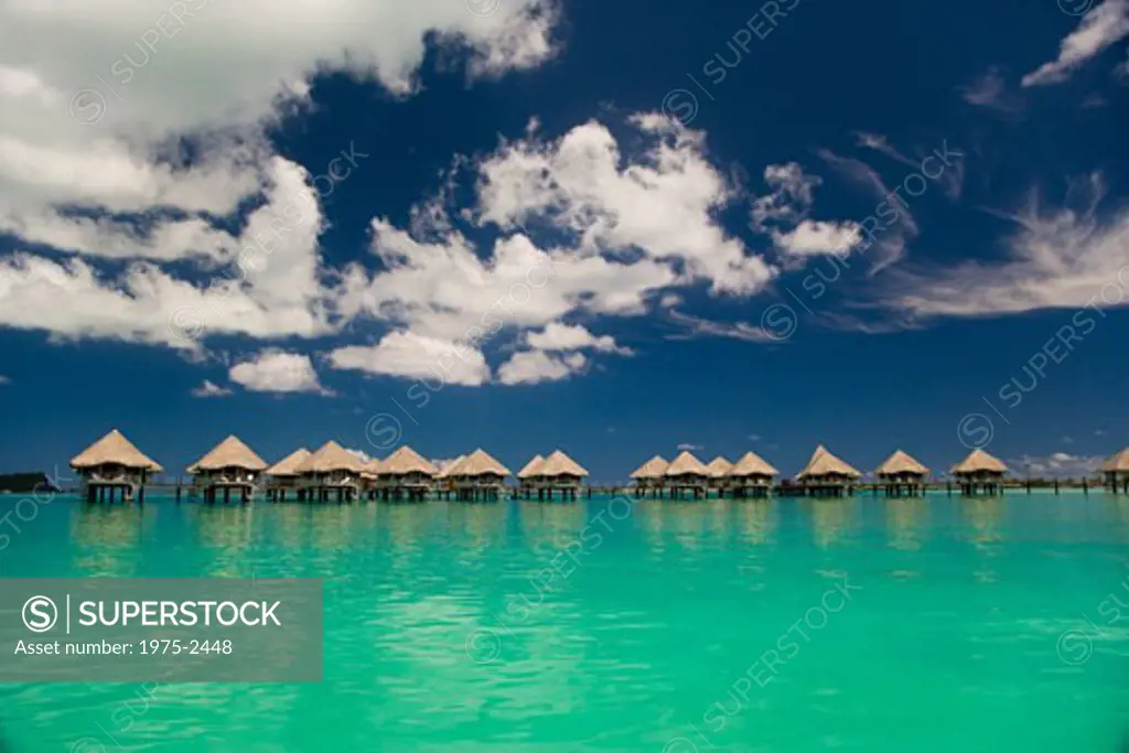 Reflection of resort beach huts in the sea, Bora Bora, Tahiti, French Polynesia