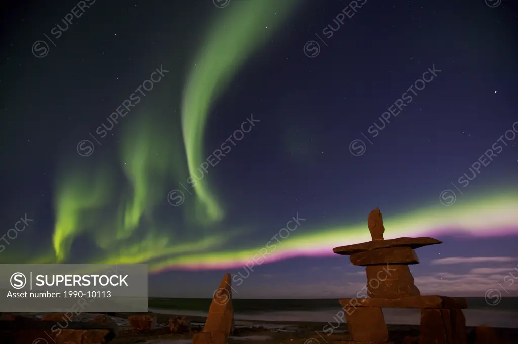 Northern Lights, Aurora borealis, above an inukshuk in the town of Churchill, Hudson Bay, Manitoba, Canada.